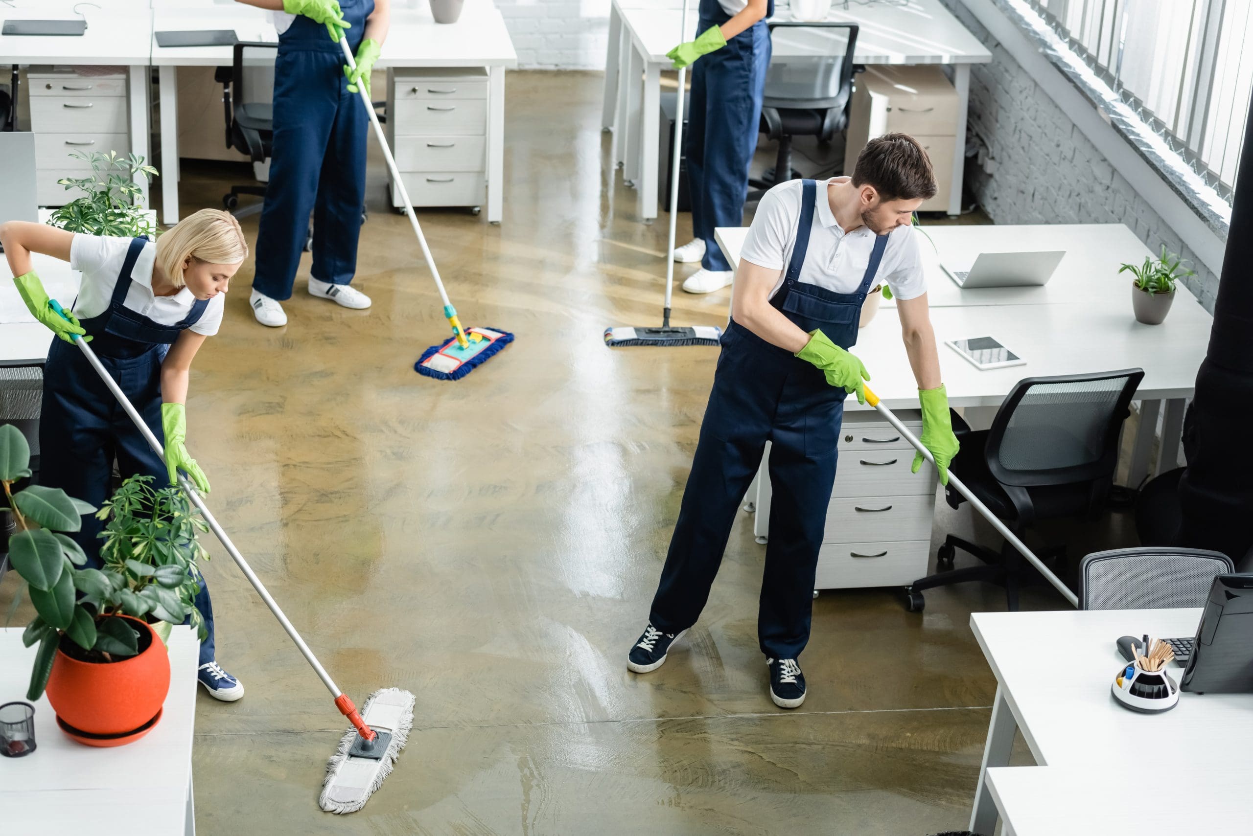 A team of individuals tidying up an office space, ensuring cleanliness and organization.